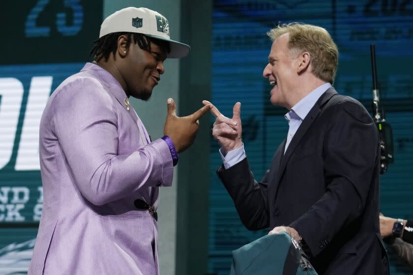 Georgia defensive lineman Jalen Carter, left, reacts with NFL Commissioner Roger Goodell after being chosen by the Philadelphia Eagles with the ninth overall pick during the first round of the NFL football draft, Thursday, April 27, 2023, in Kansas City, Mo. (AP Photo/Jeff Roberson)