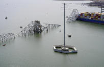 In this aerial image released by the Maryland National Guard, the cargo ship Dali is stuck under part of the structure of the Francis Scott Key Bridge after the ship hit the bridge, Tuesday, March 26, 2024, in Baltimore. (Maryland National Guard via AP)