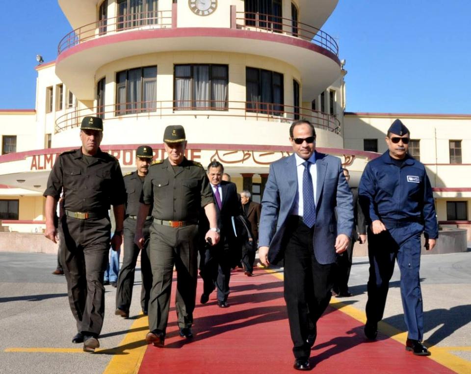 In this image released on the official Facebook page of the Egyptian Military Spokesman of the Armed Forces, Egyptian army chief Field Marshal Abdel-Fattah el-Sissi, second right, and Egypt's Foreign Minister Nabil Fahmy, center background, prepare to depart to Moscow from a military airport, in Cairo, Egypt, Wednesday, Feb. 12, 2014. El-Sissi headed to Moscow on Wednesday amid reports of a $2 billion arms deal in the making that would significantly expand Russia's military influence with a key U.S. ally in the Middle East. (AP Photo/The Official Facebook Page of the Egyptian Military Spokesman of the Armed Forces)