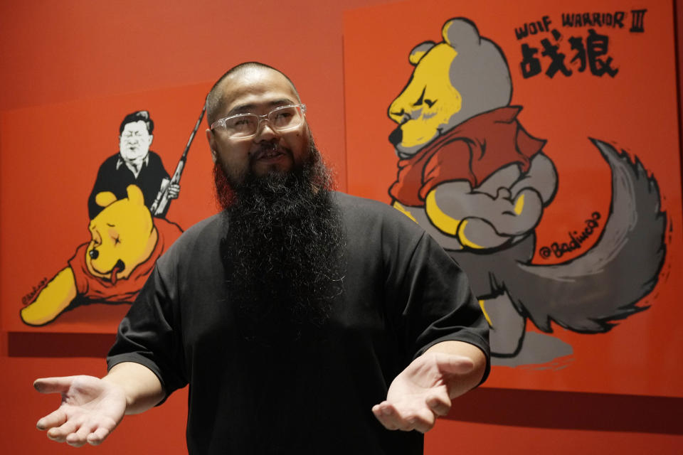 Chinese dissident artist Badiucao speaks as he stands in front of his works ahead of the opening of a new exhibition in Warsaw, Poland on Friday, June 16, 2023. The museum faced demands from the Chinese embassy not to open the exhibition, "Tell China's Story Well," which is highly critical of China's human rights record. (AP Photo/Czarek Sokolowski)