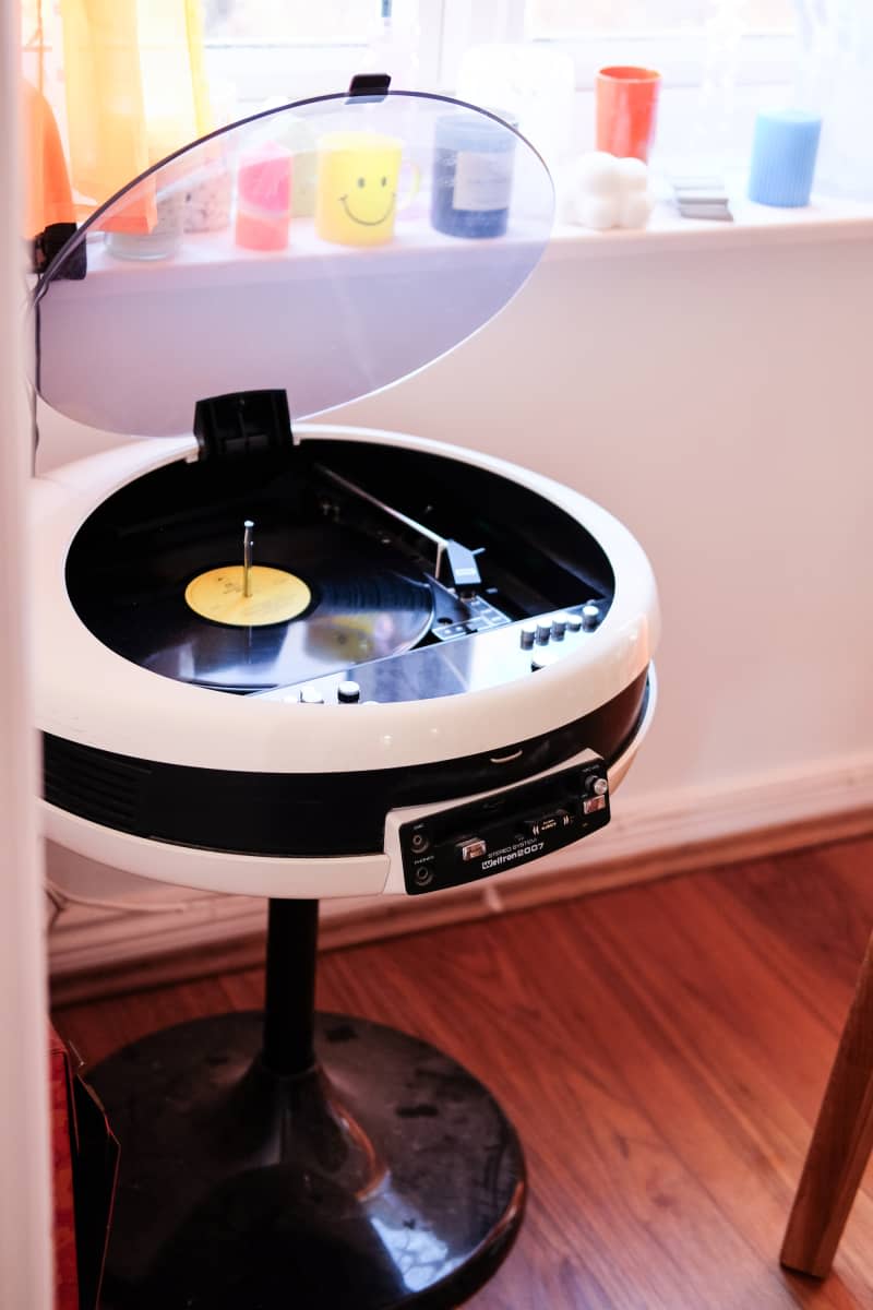 Retro record album player sits in corner of white room.