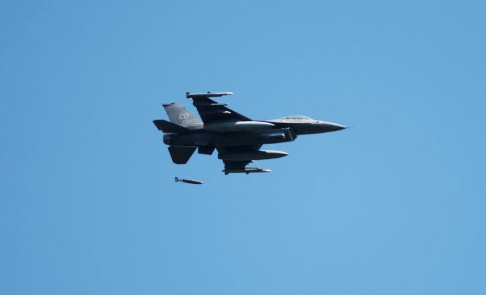 a fighter aircraft drops munitions in a training exercise