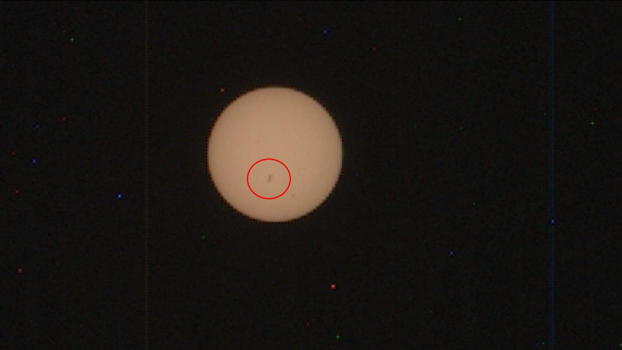  a dark spot can be seen on a pale yellow sun 