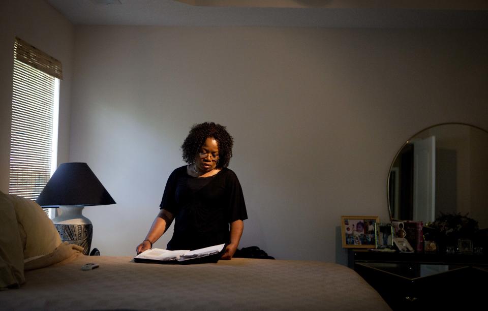 Patricia Jackson sifts through bank documents in the bedroom of her home Saturday, June 16, 2012, in Marietta, Ga. On a suburban cul-de-sac northwest of Atlanta, the Jacksons are struggling to keep a house worth $100,000 less than they owe. Their voices and those of many others tell the story of a country that, for all the economic turmoil of the past few years, continues to believe things will get better. But until it does, families are trying to hang on to what they've got left. The Great Recession claimed nearly 40 percent of Americans' wealth, the Federal Reserve reported last week. The new figures, showing Americans' net worth has plunged back to what it was in 1992, left economists shuddering. (AP Photo/David Goldman)