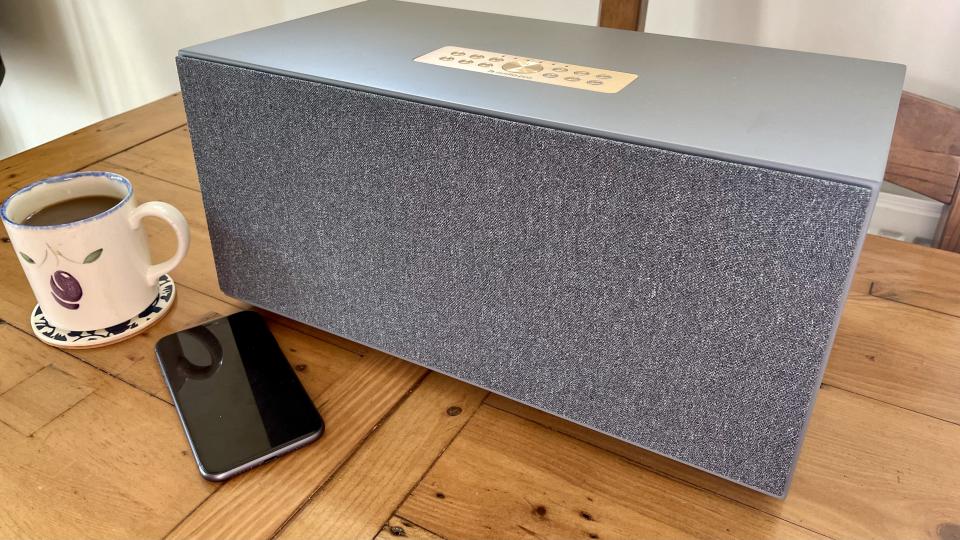 Audio Pro C20 on a table, with a mug of coffee and a smartphone beside it