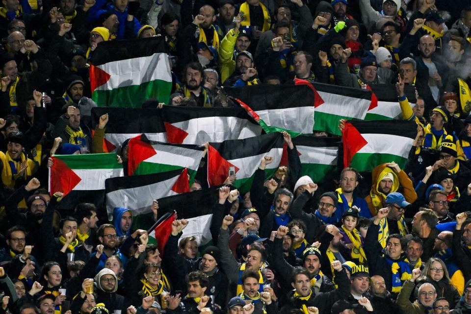 Fans hold Palestinian flags during a Belgian ProLeague soccer game in Brussels on Nov. 5. (Belga/AFP via Getty Images - image credit)