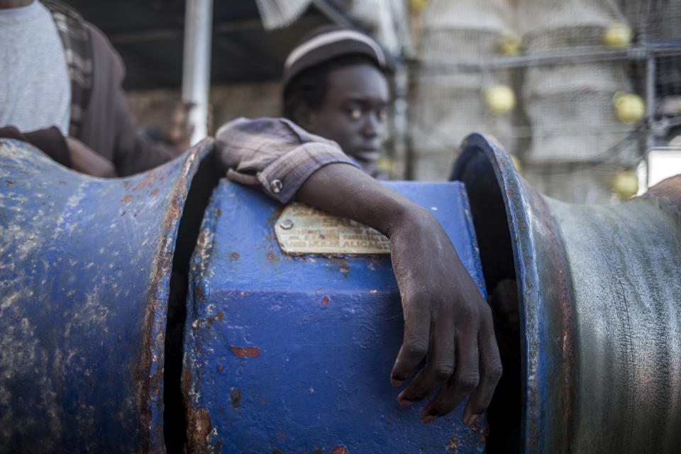 In this photo taken on Saturday, Nov. 24, 2018 photo, A migrant from Nigeria stands on the deck of Nuestra Madre de Loreto, a Spanish fishing vessel that rescued twelve people two days ago a north of the Libyan shore. The Open Arms assisted migrants medically and provided them with food, blankets and clothes. (AP Photo/Javier Fergo)