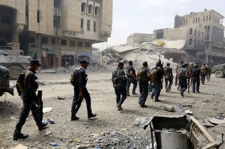 Members of Iraqi federal police carry their weapons during fighting with Islamic State militants at the frontline in the Old City of Mosul, Iraq July 7, 2017. REUTERS/Ahmed Saad