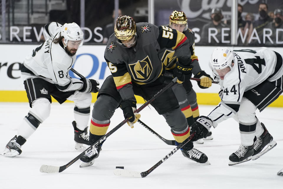 Vegas Golden Knights right wing Keegan Kolesar (55) vies for the puck with Los Angeles Kings defenseman Mikey Anderson (44) and defenseman Drew Doughty (8) during the second period of an NHL hockey game Monday, March 29, 2021, in Las Vegas. (AP Photo/John Locher)