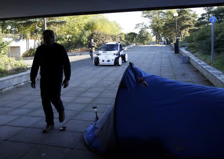 A driverless pod approaches a homeless person's tent as it is tested in Milton Keynes, Britain, October 11, 2016. REUTERS/Darren Staples