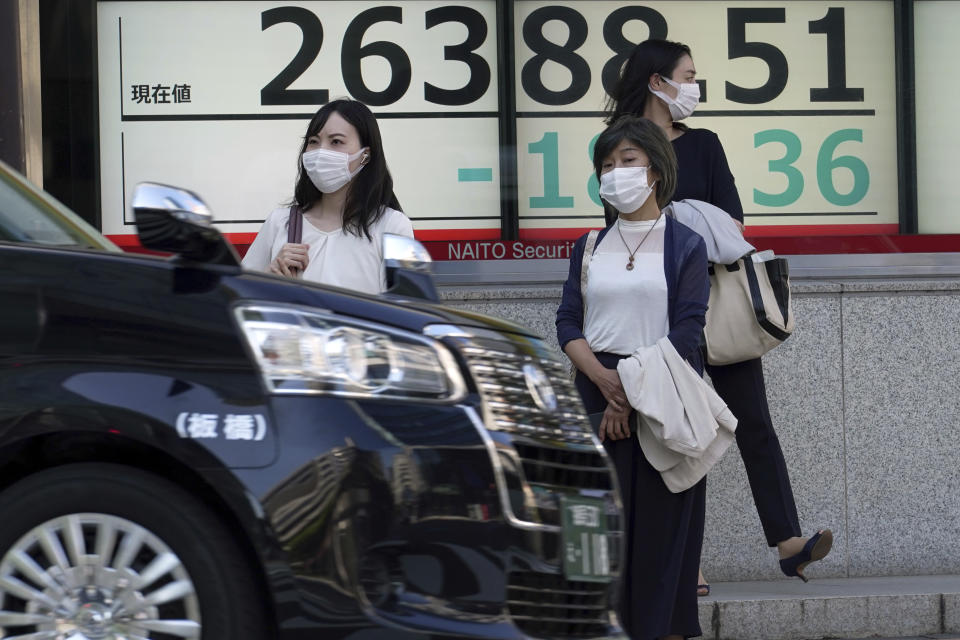 People wearing protective masks stand in front of an electronic stock board showing Japan's Nikkei 225 index at a securities firm Wednesday, Sept. 28, 2022, in Tokyo. Asian shares tumbled Wednesday after a wobbly day ended with mixed results on Wall Street as markets churn over the prospect of a possible recession. (AP Photo/Eugene Hoshiko)