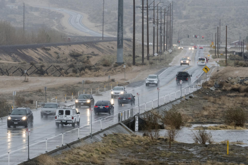 Traffic drives over Rock Springs Road as rain water begins filling the Mojave River in Hesperia CA on Thursday January 17, 2019. The Mojave River flows underground the majority of the year. (James Quigg/The Daily Press via AP)