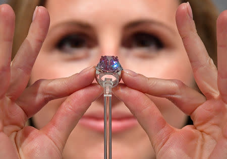 Jewellery Specialist at Christie's, Rachel Evans-Omeyer, poses with an 18.96 carat Fancy Vivid Pink Diamond prior to it being auctioned in November in Geneva, at Christie's in London, Britain, September 25, 2018. REUTERS/Toby Melville