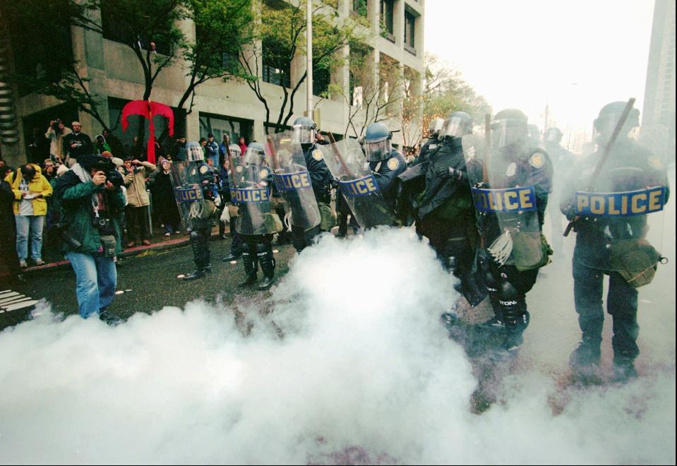 - FILE - In this Nov.30 1999 file photo, Seattle police clear an intersection of World Trade Organization protesters at Sixth and University Streets, in Seattle. In the 20 years since the 1999 World Trade Organization summit that left Seattle a smoky battleground between police and demonstrators, protesters at international summits have used a range of tactics _ from rhetorical to anarchical _ to fight against global capitalism. (AP Photo/Stevan Morgain, File)