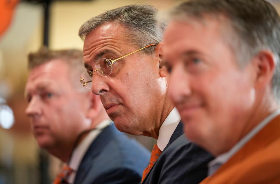 Texas athletic director Chris Del Conte, middle, is flanked by new baseball coach Jim Schlossnagle, left, and UT President Jay Hartzell at Schlossnagle's introductory news conference June 26. Schlossnagle's hiring from Texas A&M adds to one of the most formidable collections of head coaches in America.