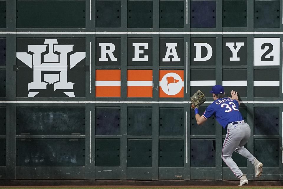 Texas Rangers' Evan Carter catches a ball hit by Houston Astros' Alex Bregman at the wall during the first inning of Game 1 of the baseball AL Championship Series Sunday, Oct. 15, 2023, in Houston. (AP Photo/David J. Phillip)