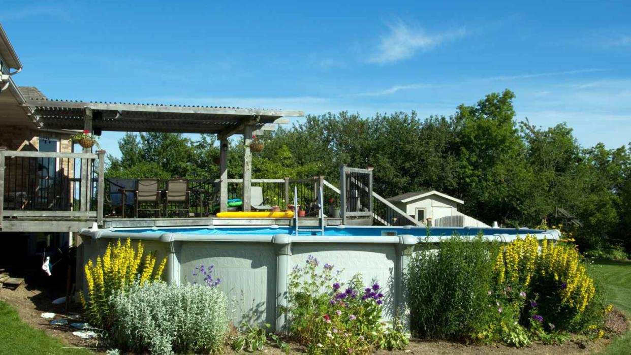 A backyard deck and above ground swimming pool