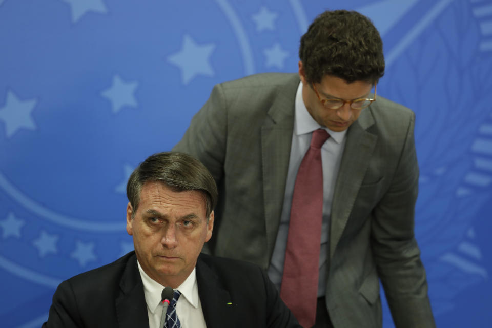 Brazil's President Jair Bolsonaro, front, and his Environment Minister Ricardo Salles prepare to give a press conference on deforestation in the Amazon at the Planalto presidential palace in Brasilia, Brazil, Thursday, Aug. 1, 2019. Bolsonaro is threatening to dismiss officers at the agency that monitors deforestation in the Amazon over its publication of data he disagrees with. (AP Photo/Eraldo Peres)