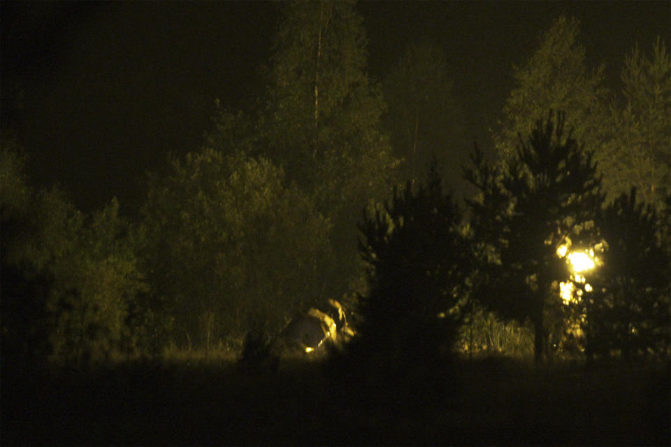 A lamp Illuminates parts of a private jet after a crash near the village of Kuzhenkino, Tver region, Russia, early Thursday, Aug. 24, 2023. Russian mercenary leader Yevgeny V. Prigozhin, the founder of the Wagner Group, reportedly died when a private jet he was said to be on crashed on Aug. 23, 2023, killing all 10 people on board. (AP Photo)