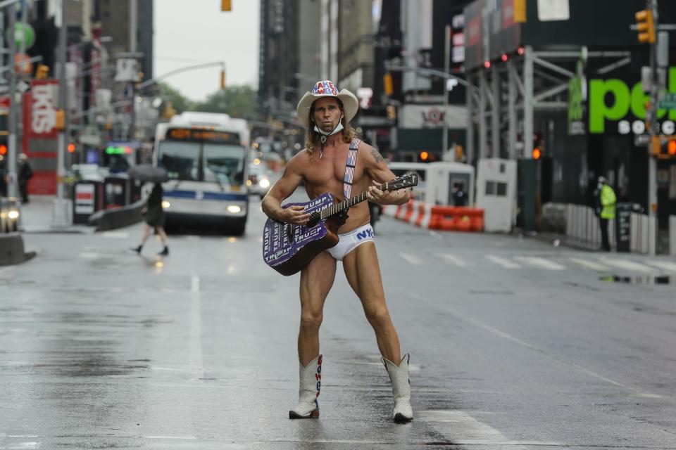 Robert Burck, el Naked Cowboy (Vaquero desnudo), posa para los fotógrafos en Times Square durante la pandemia de coronavirus en Nueva York, el sábado 23 de mayo de 2020. (AP Photo/Frank Franklin II)