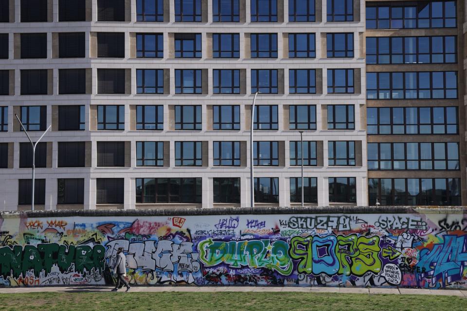 New buildings stand behind a surviving section of the Berlin Wall with graffiti on March 27, 2024 in Berlin, Germany.