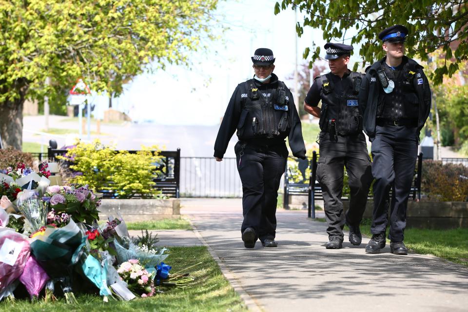 Police officers look at floral tributes for Julia James in AyleshamGetty Images