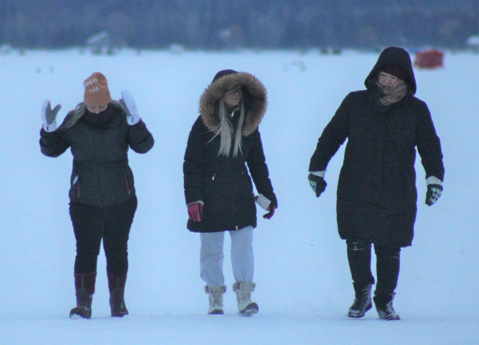 A group of people walk on the Black Lake Ice before the official start of sturgeon season on Saturday, Feb. 4, 2023. Tons of attendees were excited to check out the fish caught by anglers during the event on Saturday.