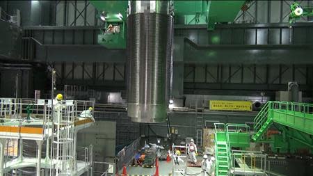 The cask with 22 fuel rods is lifted and moved by workers during operations to move the cask from the reactor building to another building where a common fuel pool is located, at Tokyo Electric Power Co's (TEPCO) Fukushima Daiichi nuclear power plant in Fukushima prefecture, November 21, 2013, in this handout video grab image taken and released by TEPCO. REUTERS/Tokyo Electric Power Co/Handout via Reuters