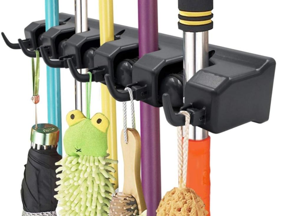 If you're in a small space, this broom holder can come in handy for the brushes and mops you use on cleaning day. You can also use it in your entryway for keys, umbrellas and masks &mdash; a win-win in our book. <a href="https://amzn.to/31kRvGr" target="_blank" rel="noopener noreferrer">Find it for $18 at Amazon</a>.