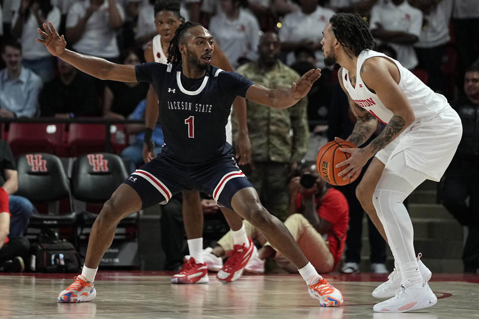 Jackson State forward Zeke Cook (1) defends Houston guard Emanuel Sharp (21) during the first half of an NCAA college basketball game, Saturday, Dec. 9, 2023, in Houston. (AP Photo/Kevin M. Cox)