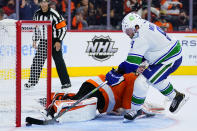 Vancouver Canucks' J.T. Miller, right, scores a goal past Philadelphia Flyers' Carter Hart during a shootout in an NHL hockey game, Friday, Oct. 15, 2021, in Philadelphia. (AP Photo/Matt Slocum)