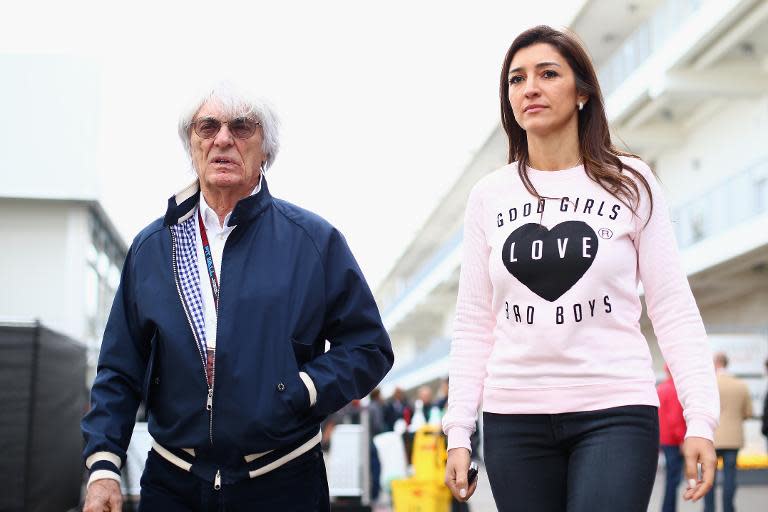 Formula One supremo Bernie Ecclestone and his wife Fabiana Flosi walk through the pits during the US F1 Grand Prix at the Circuit of The Americas in Austin, Texas, on November 14, 2013