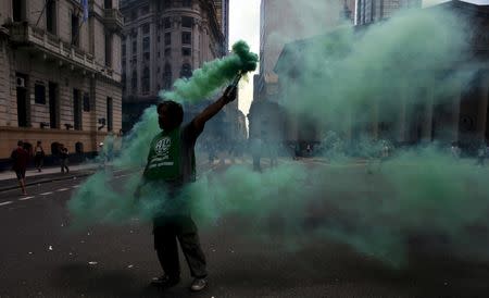 A state worker lights a flare near Plaza de Mayo square during a protest in Buenos Aires, Argentina, February 24, 2016. REUTERS/Marcos Brindicci