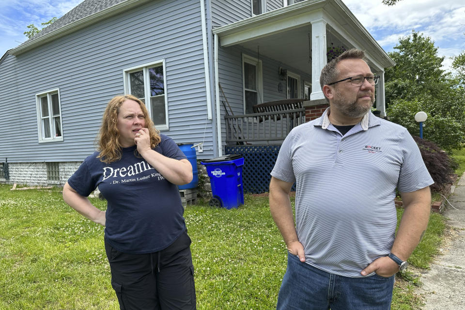 Jay and Tanya Aho are interviewed outside their home, June 22, 2023, in Detroit. The Ahos have seen improvements in their eastside neighborhood. Along nearby Sylvester Street, about half a dozen vacant homes have been torn down and just one ramshackle house remains, with peeling siding, sagging roof and surrounded by waist-high weeds, trees and a thriving rose bush. Rabbits, deer and pheasants have started to appear in the grass and weed-filled vacant lots. (AP Photo/Mike Householder)