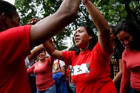 Supporters of Venezuela's President Nicolas Maduro dance as they attend a rally against the application of Organization of American States (OAS) democratic charter, in Caracas, Venezuela June 23, 2016. REUTERS/Marco Bello