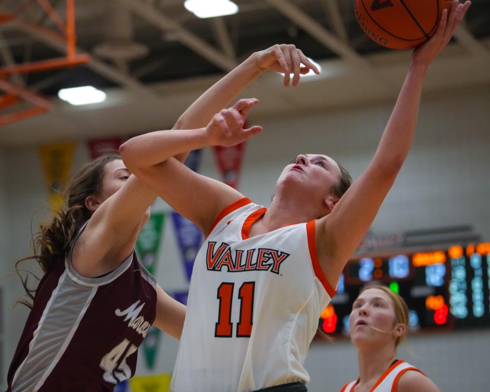 West Des Moines Valley's Brynne Katcher (11) goes up for a basket against Dowling Catholic's Alex Gaskell (45) during Tuesday's game at Valley High School.