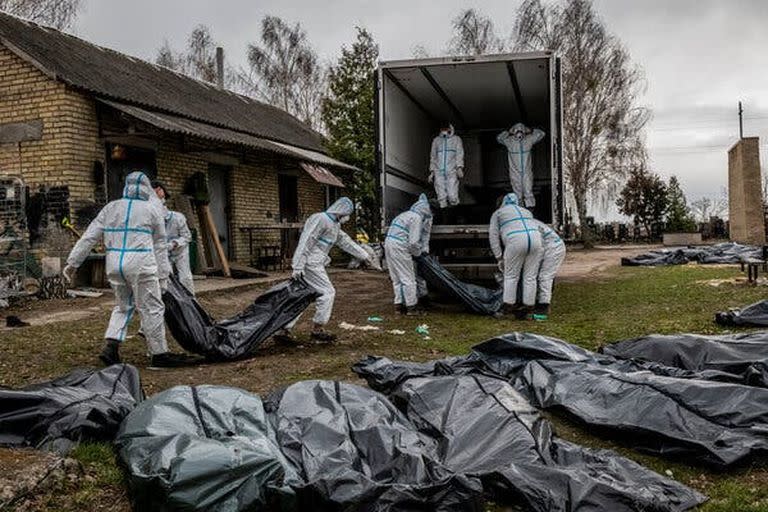 Voluntarios cargando a los muertos en un camión en Bucha, Ucrania.