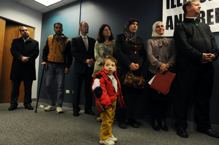 Syrian refugee Ameer Alrife stands in front of his parents and community leaders during a press conference in Chicago, Illinois