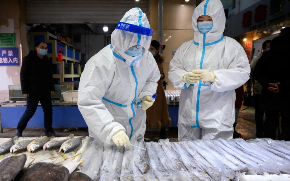 A staff member from the center for disease control and prevention collects a swab from a seafood stall for nucleic acid testing, at a market following the coronavirus outbreak, in Taiyuan, Shanxi province - via Reuters