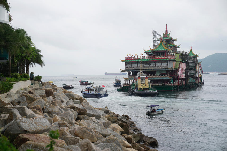 Hong Kong's iconic Jumbo Floating Restaurant is towed away in Hong Kong, Tuesday, June 14, 2022. Hong Kong's iconic restaurant on Tuesday departed the city, after its parent company failed to find a new owner and lacked funds to maintain the establishment amid months of COVID-19 restrictions. (AP Photo/Kin Cheung)