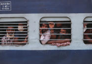 Migrant workers look out a train window before moving to their home states, at Hyderabad Railway Station in Hyderabad, India, Saturday, May 23, 2020. India's lockdown was imposed on March 25 and has been extended several times. On May 4, India eased lockdown rules and allowed migrant workers to travel back to their homes, a decision that has resulted in millions of people being on the move for the last two weeks. (AP Photo/Mahesh Kumar A.)