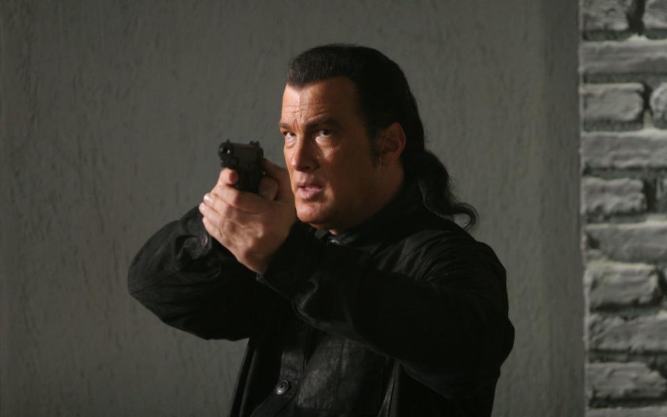 "Hard to Kill", "Alarmstufe Rot", "Auf brennendem Eis" - Filme mit Steven Seagal (hier in "Attack Force"), der 1988 als "Nico" seinen Durchbruch feierte, standen immer für Action, Action, Action. Die Pose mit versteinerter Miene und schussbereiter Waffe gehörte für den Hollywood-Granitfelsen über Jahre zum Standard-Repertoire. (Bild: Sony)