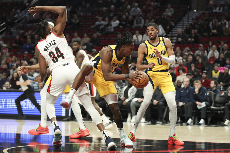 Indiana Pacers forward Aaron Nesmith (23) grabs a rebound from above Portland Trail Blazers forward Jabari Walker (34) during the first half of an NBA basketball game Friday, Jan. 19, 2024, in Portland, Ore. (AP Photo/Amanda Loman)