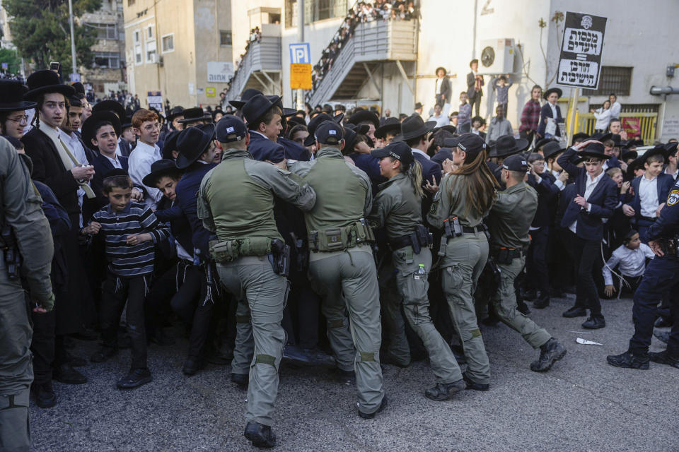 Israeli border police officers push back Ultra-Orthodox Jewish men during a protest against army recruitment, in Jerusalem, Thursday, April 11, 2024. Ultra-Orthodox men have long received exemptions from military service, which is compulsory for most Jewish men, generating widespread resentment. The Supreme Court has ordered the government to present a new proposal to force more religious men to enlist. (AP Photo/Ohad Zwigenberg)