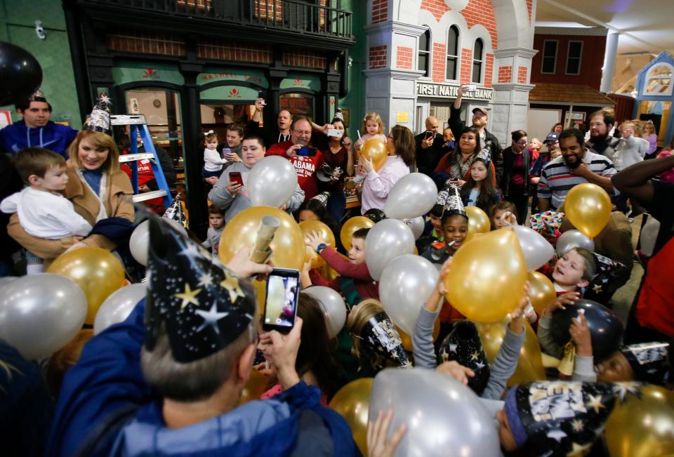 Children watch as balloons fall to the floor during the New Year's Eve balloon drop at the Children's Hands-on Museum in downtown Tuscaloosa on Saturday, Dec. 30, 2017.