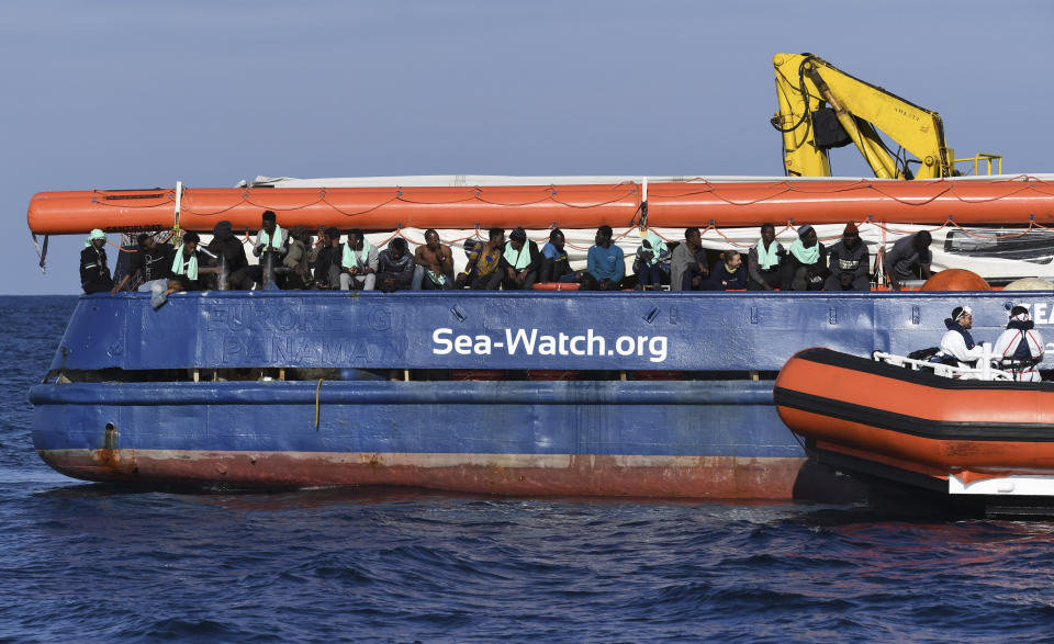 A coastguard boat approaches the German humanitarian group's rescue boat Sea Watch 3, to deliver food and blankets for the cold, off the coast of Syracuse, Italy, Sunday, Jan. 27, 2019. The Italian coast guard is bringing socks, shoes, bread and fruit to 47 migrants who have been stranded at sea for nine days aboard a German ship. (AP Photo/Salvatore Cavalli)