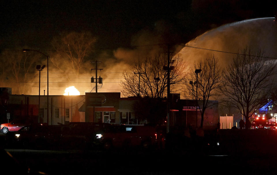 Fire departments battle an industrial fire near 15 Mile Road and Groesbeck Highway in the Detroit suburb of Clinton Township, on Monday, March 4, 2024. (Robin Buckson/Detroit News via AP)
