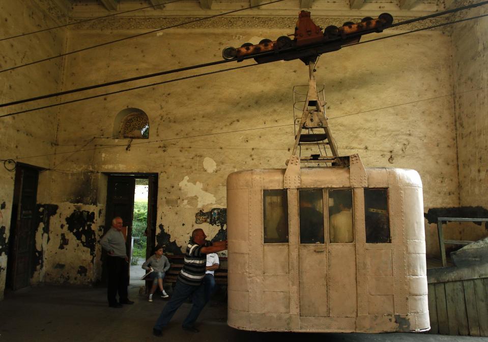 A commuter pushes a 60-year-old cable car in the town of Chiatura