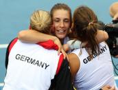 Andrea Petkovic, center, of Germany celebrates with her teammates after winning 6-1, 7-6, in her semifinal match against Samantha Stosur of Australia during the Fed Cup semifinals between Australia and Germany in Brisbane, Australia, Saturday, April 19, 2014. (AP Photo/Tertius Pickard)