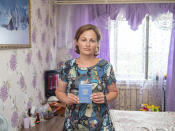 Lyudmila Bolbad, an evacuee from Mariupol, Ukraine, holds her Russian documentation in her hotel room in Khabarovsk, Russia, on Monday, July 18, 2022. "Now we are here, deal with getting citizenship, have just gotten jobs, children in kindergarten and school. We're trying to return to a normal life somehow, to encourage ourselves to start our life from scratch," she said. "If you survived (the war), you deserve it and need to move forward, not stop." (AP Photo)